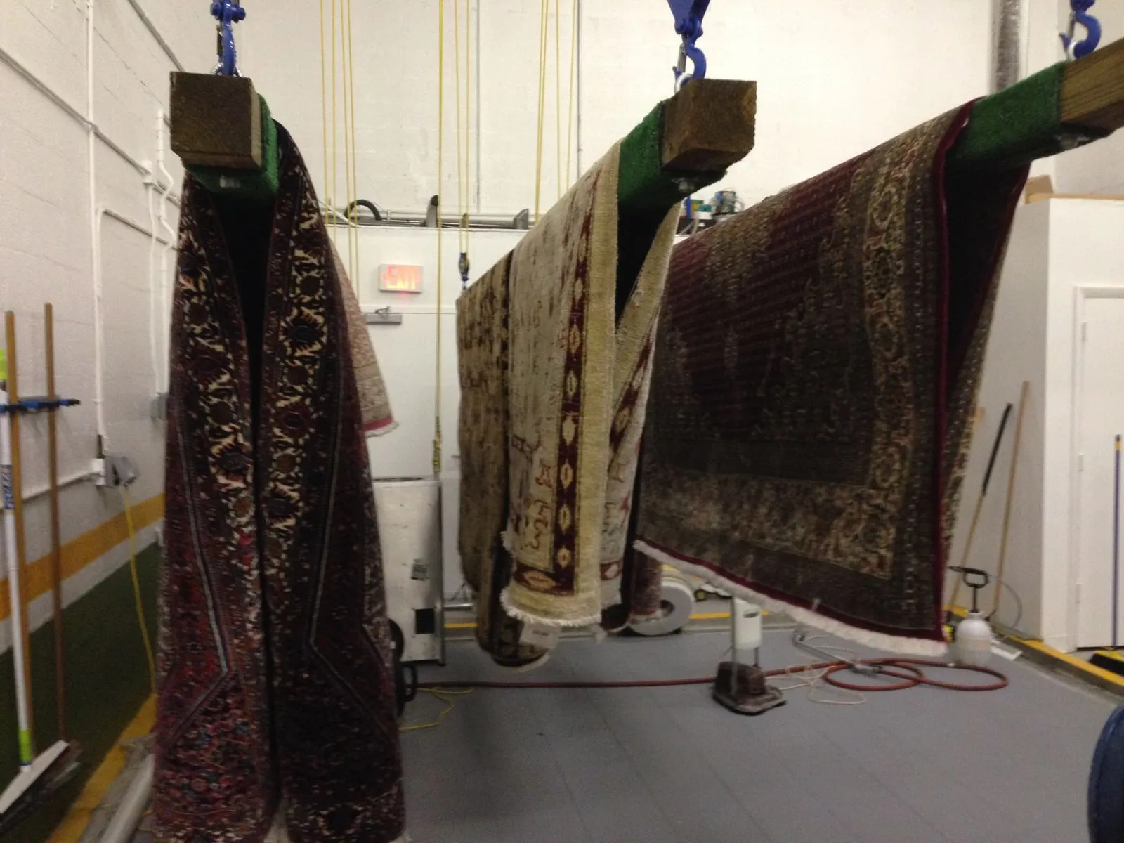 Washed rugs hanging to dry inside the plant's controlled drying room