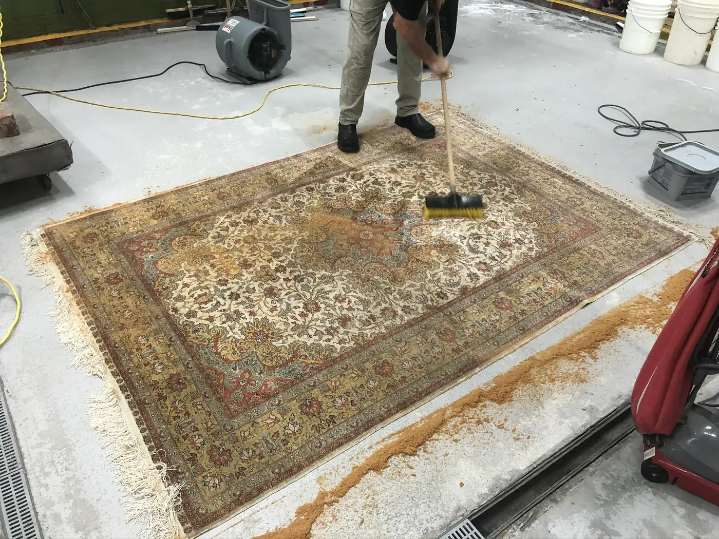 Persian rug being brushed through with shampoo suds during the wash